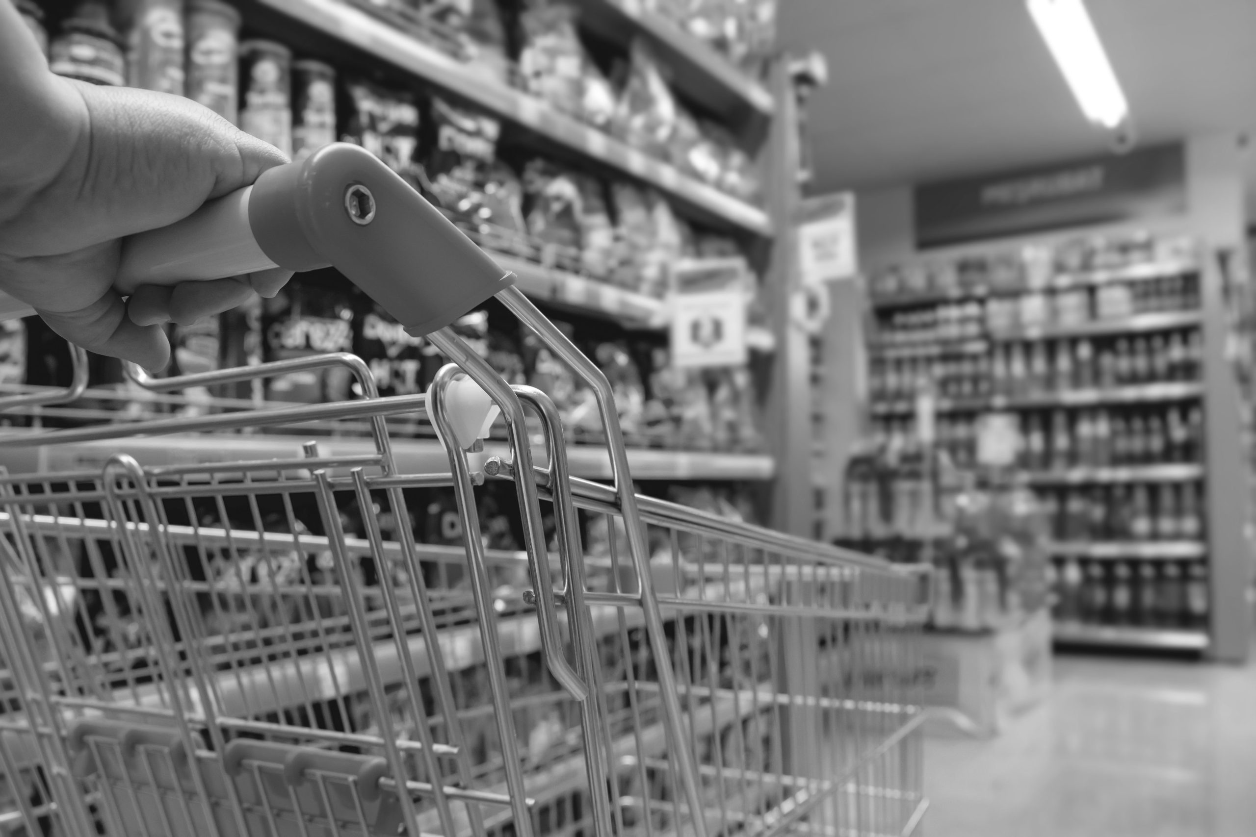 Shopping,Trolley,Cart,Against,Modern,Supermarket,Aisle,Blurred,Background